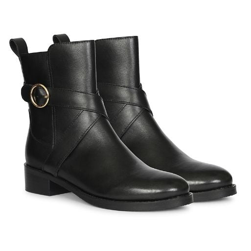 A pair of black leather ankle boots with a low block heel, a decorative strap across the instep featuring a gold-tone circular buckle