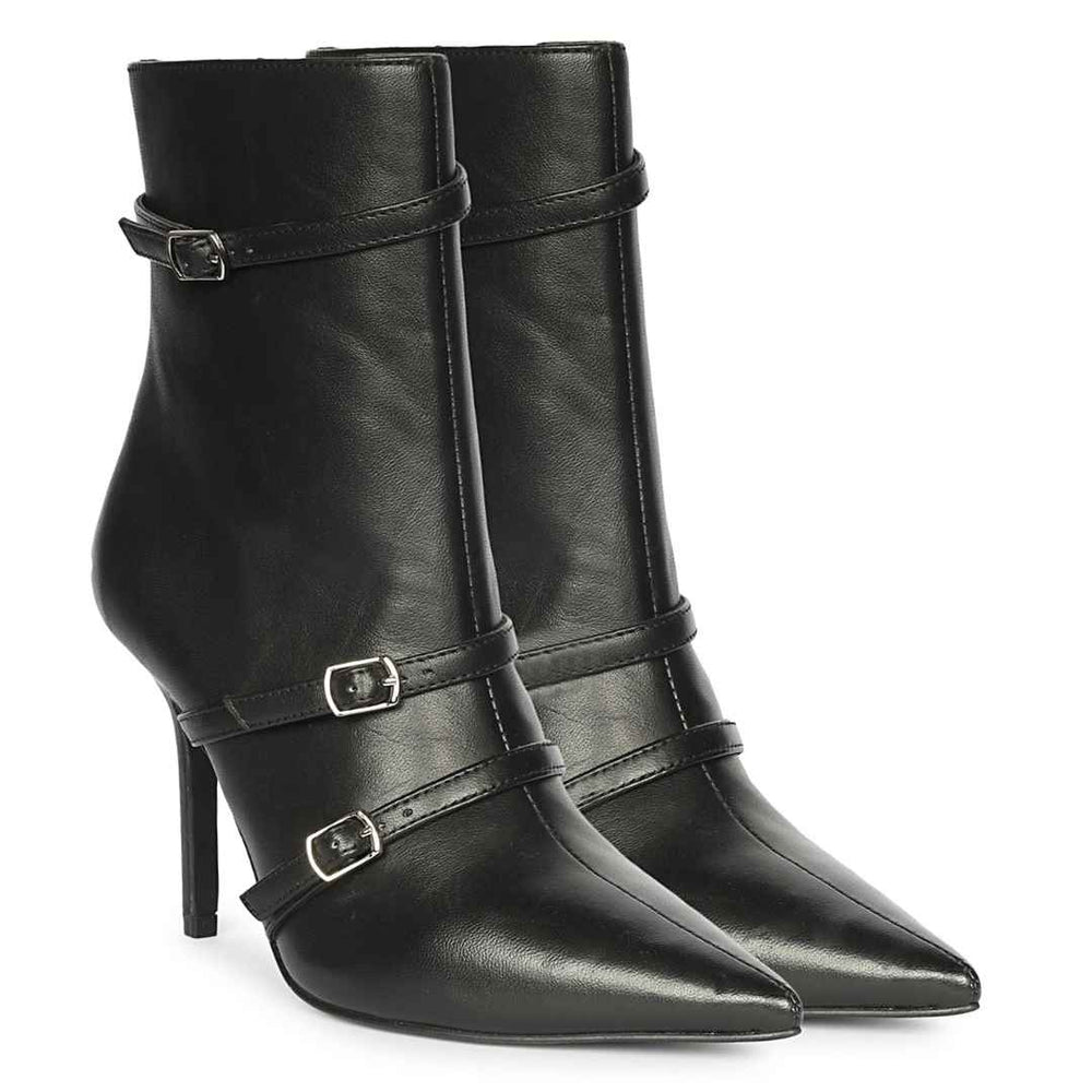 A pair of black leather ankle boots with pointed toes, high stiletto heels, and decorative silver buckle straps