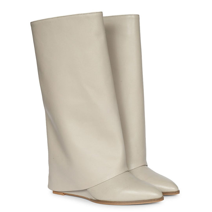 A pair of tall, light beige leather boots with a pointed toe and a low flat heel