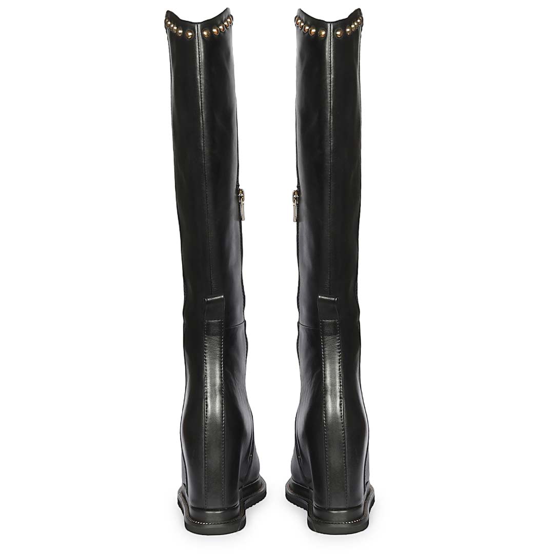 A pair of black leather knee-high boots shown from the back, featuring gold-tone metal studs along the top collar and a side zipper