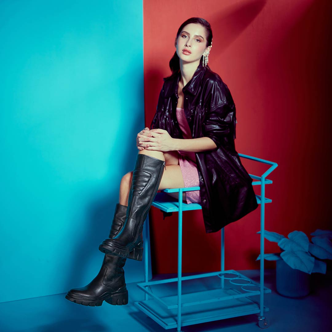 Women's black leather knee high boots by Saint Eloise, dramatic editorial lifestyle shot